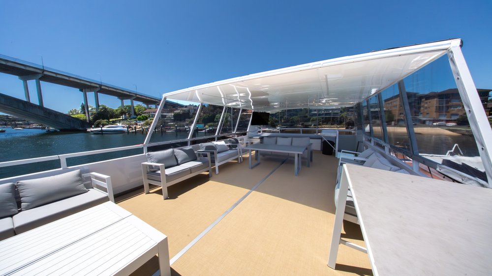 Deckhouse upper deck - covered entertaining area with lounges, dining table and clear blinds